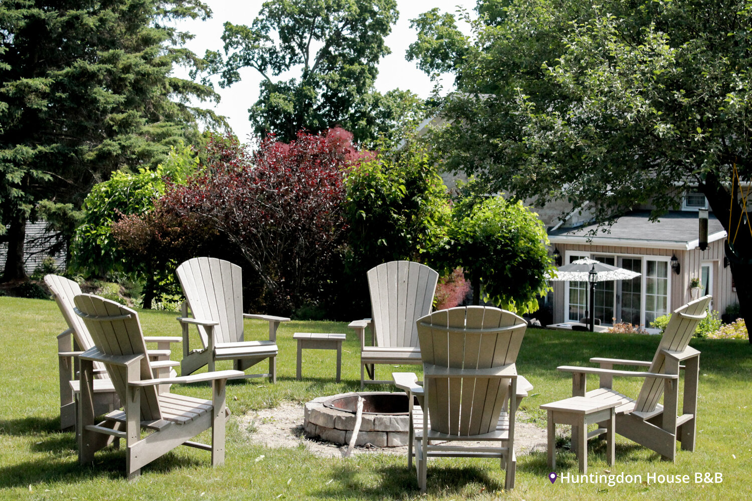 Huntingdon House B&B in Stirling. Chairs setup around a fire pit, with trees and house in background on a bright sunny day
