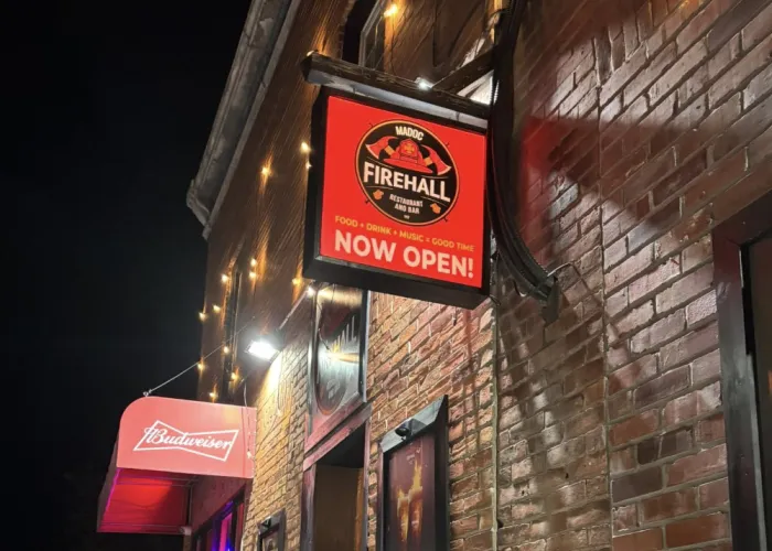 Madoc Firehall Food Fun & Friends Restaurant. A red sign can be seen outside of a brick building with the words Firehall on them.
